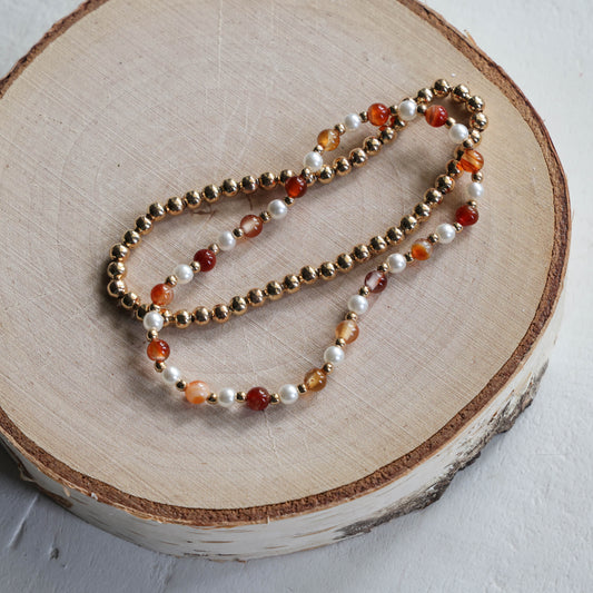 Paired Gold, Orange, and Pearl Bracelets