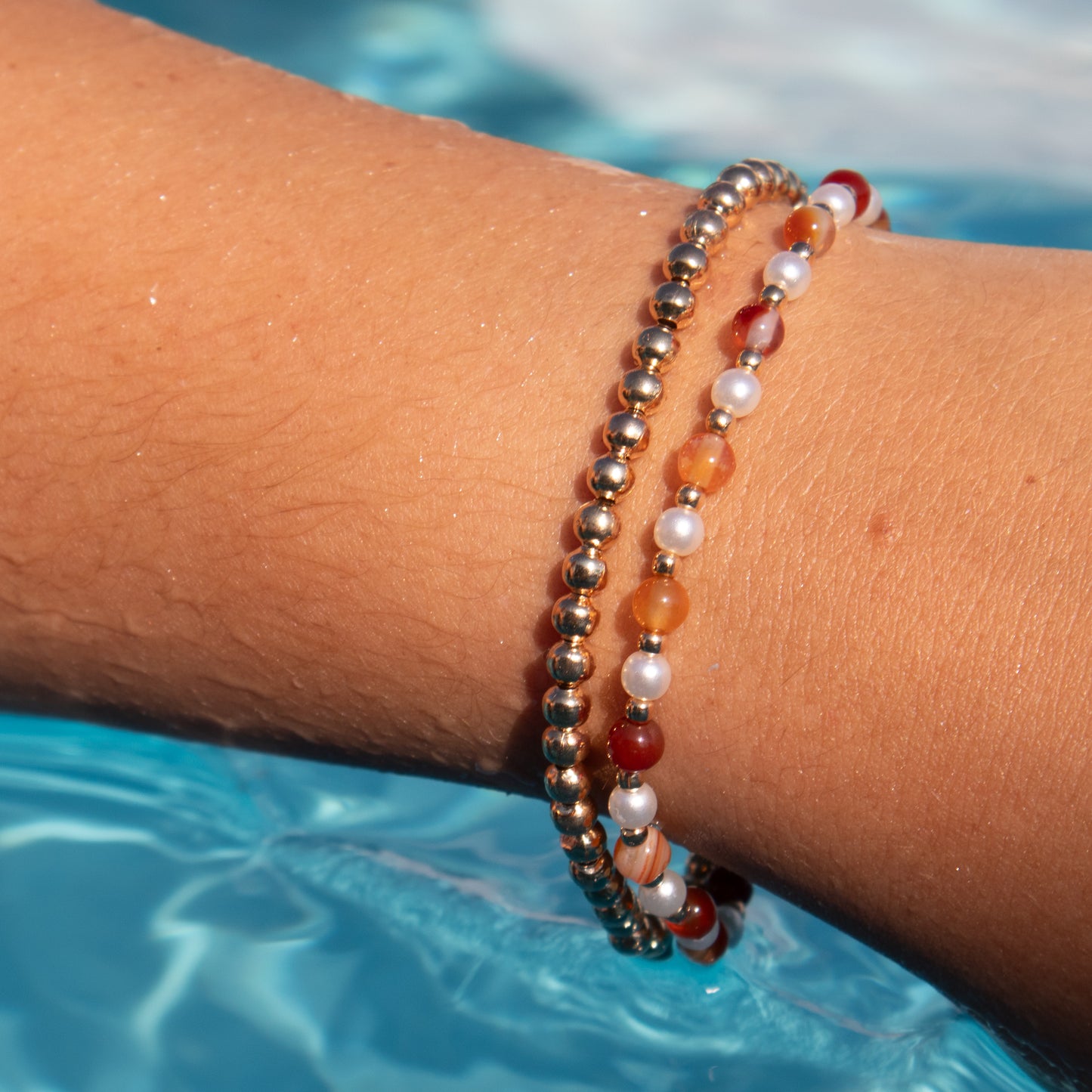 Paired Gold, Orange, and Pearl Bracelets